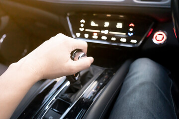 Male hand holds automatic gear stick inside modern sports car, concept travel driving