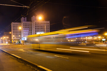 Naklejka na ściany i meble The movement of a blurred bus along the overpass in the evening.