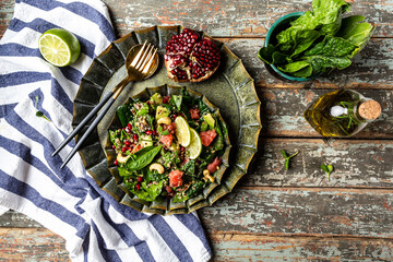 healhty vegan lunch bowl. Avocado, quinoa, spinach, grapefruit, pomegranate, nuts and microgreens vegetables salad. Top view