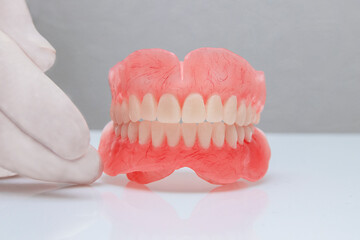 False teeth prosthesis. Doctor Dentist. A dental technician holds a false jaw in his hand.
