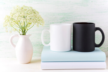 Black and white mug mockup with books and white flowers