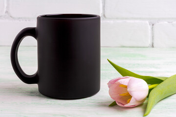 Black coffee mug mockup with gentle pink tulip