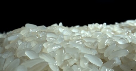 Mound of wet white rice. Wet grains of rice on Black background. Asian cuisine. Cooking concept. 