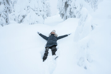 Fototapeta na wymiar Chinese girl lying on the snow and enjoying