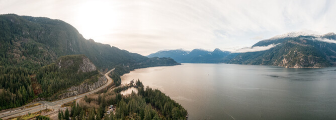 Sea to Sky Hwy in Howe Sound near Squamish, British Columbia, Canada. Aerial panoramic View. Beautiful Sunny and Cloudy Morning Sky.