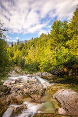 Fototapeta na wymiar Mostnica river near Stara Fuzina, Slovenia. Little waterfall.