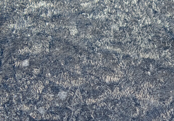 Snow frost on the blue surface close-up 