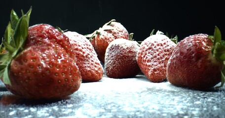 Strawberries in Powder Sugar. Macro shot of strawberries on black background. Strawberries close-up.