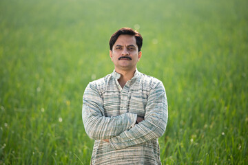 Naklejka na ściany i meble Happy Indian farmer in agricultural field outdoor