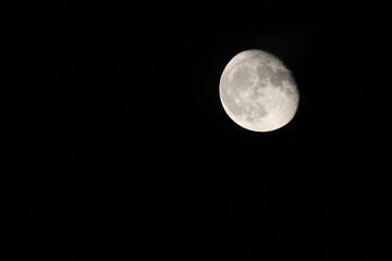 Low angle view of Moon against the clear sky at night. Close photography of the Moon with a view of craters and landscape