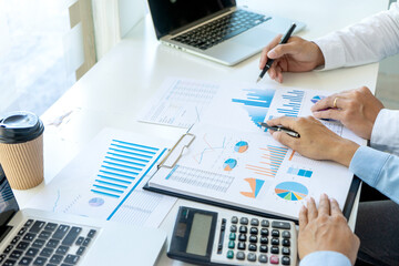 Businessman pointing at  graphs paper of business in a graph analysis