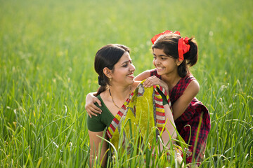 Happy mother and daughter at agricultural field