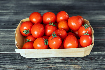tomatoes in a wooden box on a dark background on top