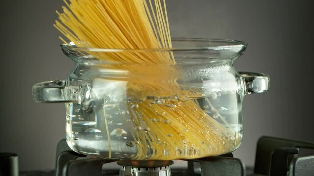 Super Slow Motion Shot of Fresh Spaghetti Falling into Boiling Salted Water at 1000 fps.