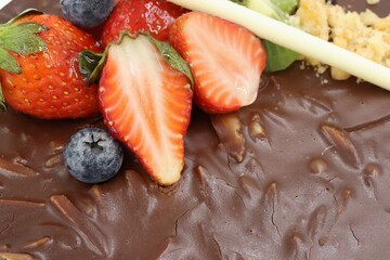 Fresh strawberries and blueberries on top of almond chocolate cake