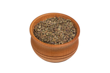 dried crushed basil leaves in wooden bowl