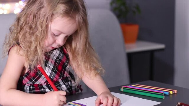 charming little blonde girl in red checkered dress painting with colorful pencils. childhood, toddler, daughter. Full HD footage.