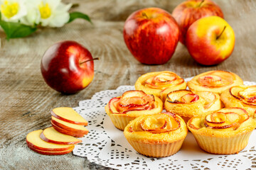 In shaped roses apple muffins on wooden background