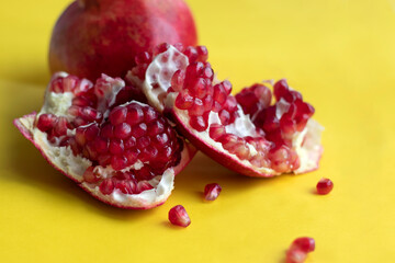 Garnet grains on yellow background. 
Juicy pomegranate