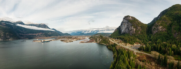 Naklejka premium Aerial panoramic view of Sea to Sky Highway with Chief Mountain in the background. Sunny Fall Season. Taken near Squamish, North of Vancouver, British Columbia, Canada.