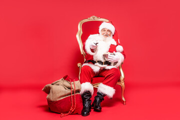 Photo of real santa claus with popcorn and remote control in hand