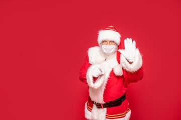 Real Santa claus in protection face mask showing stop sign by hand.