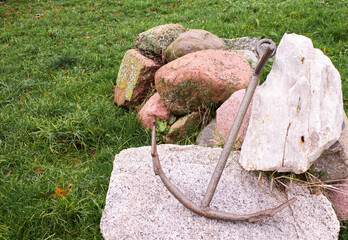 Old iron anchor on land on rocks 