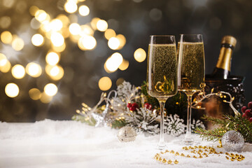 Champagne glasses and christmas decor on black sparkling holiday background