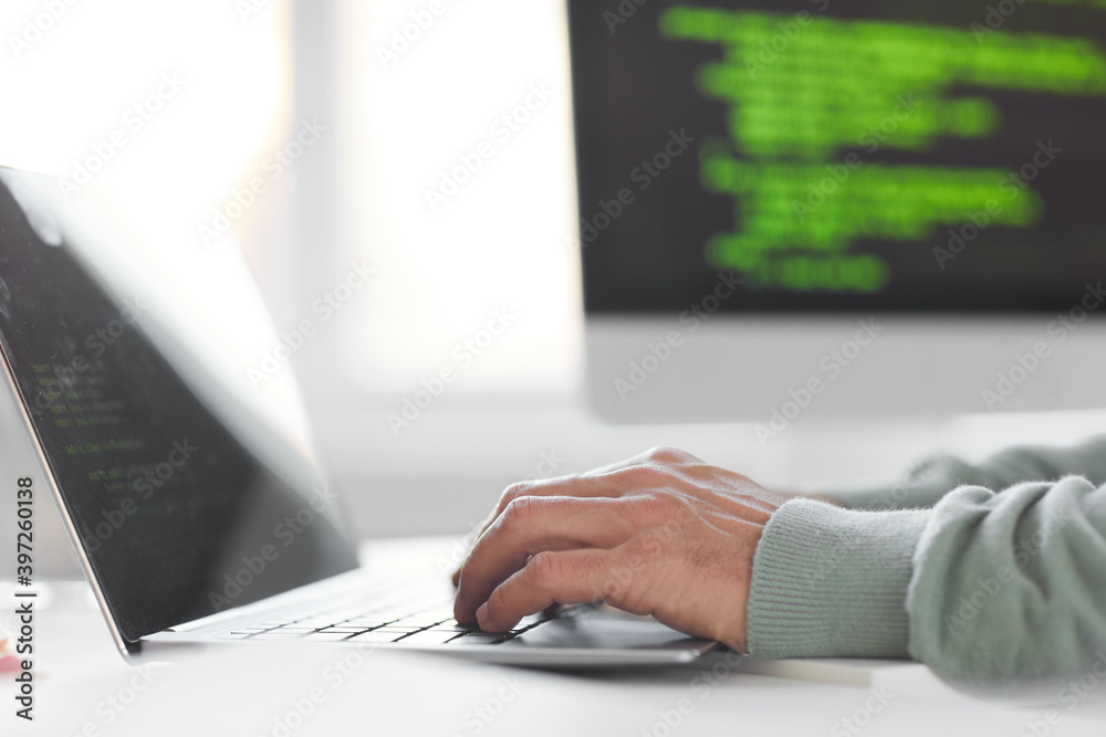 Wall mural Close-up of businessman sitting at the table typing on laptop working online at office