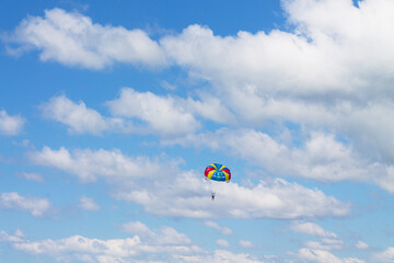 A man flies into the blue sky on a sports parachute. Lifestyle
