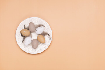 Easter eggs on beige pastel background with space for text. Flat lay image composition, top view.