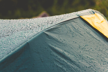 Dew drops on green tourist tent. Waterproof fabric rain, test of bad weather - 397263189