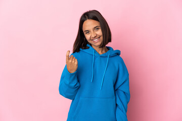 Fototapeta premium Young latin woman isolated on pink background doing coming gesture