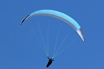 	
Paraglider flying wing in a blue sky	