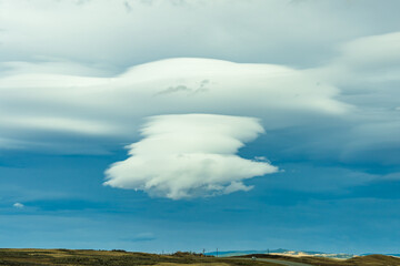 Cumulonimbus cloud in blue sky over country road in autumn season.