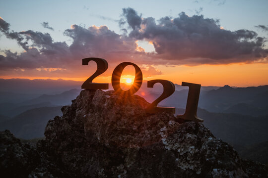 Mountain lettering with sunset light silhouette of 2021 with sunrise on the mountain for new year success start new year concept happy new year 2021