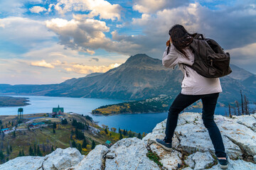 Naklejka premium Tourists taking pictures on Town of Waterton Lakes National Park in beautiful dusk. Landscape scenery in autumn foliage season. Alberta, Canada.