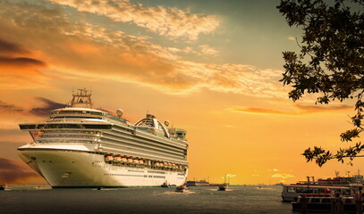 Cruise ship docked at port on sunset. Sunset over a sea.