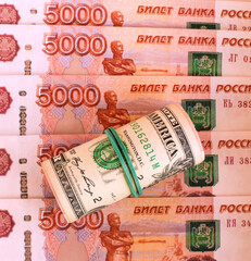 Rolled up American dollars and banknotes of 5000 Russian rubles. American sanctions. Money background. Selective focus.