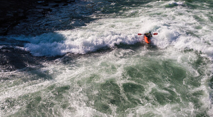 kayaker surfing whitewater on a river