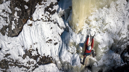 Man in red jacket ice climbing shot from above