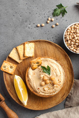 Flatlay hummus in a wooden plate, chickpeas, croutons. Dishes of chickpeas, a vegetarian dish. Copy space.