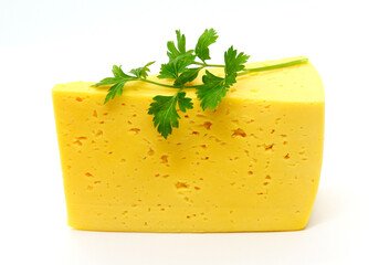 An isolated Russian cheese slab, semi hard cheese with small eyes, holes with a branch of parsley on top on a white background.