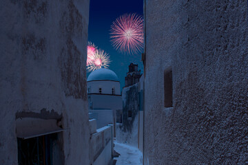 Celebratory fireworks for new year over orthodox white church in santorini during last night of year. Christmas atmosphere