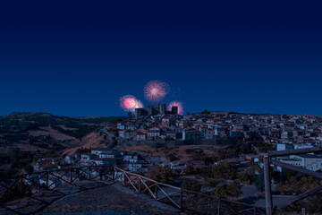 Celebratory fireworks for new year over melfi. It is see the castle in background with countryside around it. Location Melfi, Basilicata in south of Italy  during last night of year.