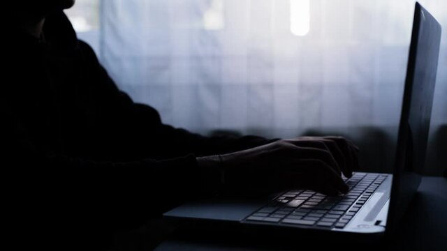 A man who opens the laptop and then works on it. Write a message. Dark image, counterpoint. Haker