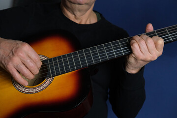 man plays the guitar, close-up hands, the concept of creativity, learning to play musical instruments, online learning