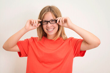 Portrait of happy playful teenager girl in eyeglasses and orange t-shirt.