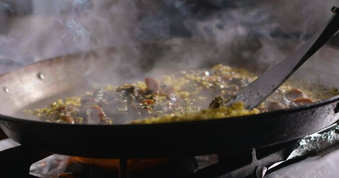 Chef preparing delicious couscous with meat in frying pan