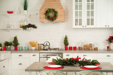 New Year's decor of modern kitchen in Scandinavian style. Serving a white plate on a red rustic napkin with a close-up and copy space. Hygge kitchen details New year concept. Selective focus